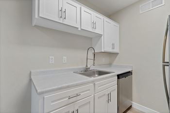 Kitchen with white cabinets and a sink and refrigerator
